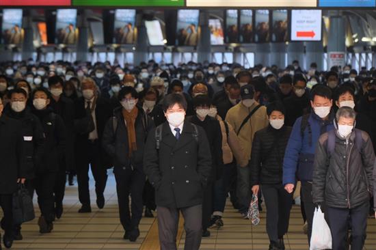 1月8日，在日本东京品川站，人们戴口罩出行。新华社 图